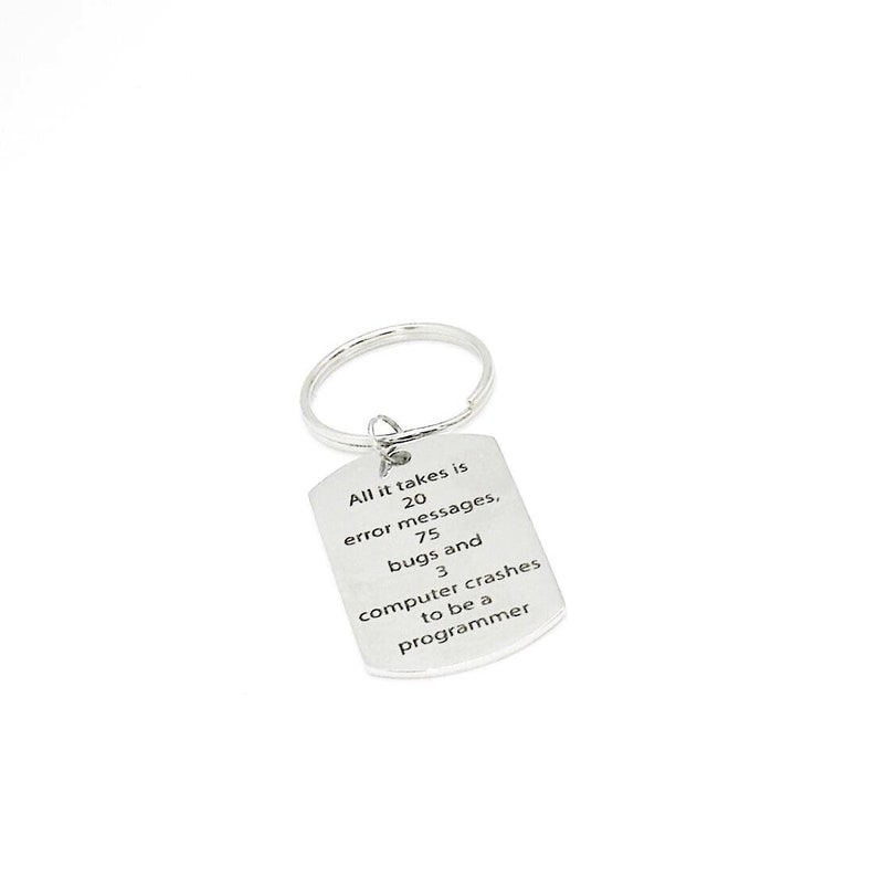 May include: Silver keychain with a rectangular tag that reads "All it takes is 20 error messages, 75 bugs and 3 computer crashes to be a programmer".