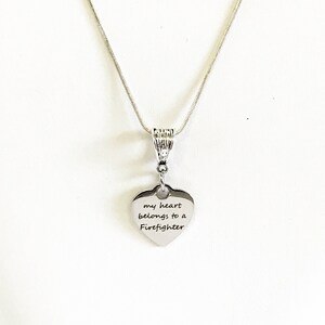 May include: Silver necklace with a heart pendant that says "my heart belongs to a Firefighter".