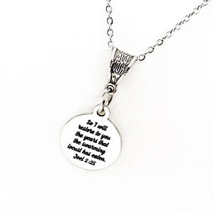 Puede incluir: Collar de plata con un colgante redondo que dice "So I will restore to you the years that the swarming locust has eaten. Joel 2:25"