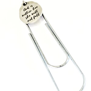 May include: Silver bookmark with a round charm that reads "God is within her she will not fall".