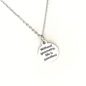 Puede incluir: Un collar de plata con un colgante redondo que dice "Sin geometría, la vida no tiene sentido".