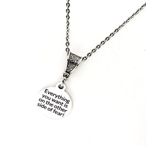May include: Silver necklace with a round pendant that says "Everything you want is on the other side of fear!"