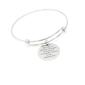 May include: A silver bangle bracelet with a charm that reads "All it takes is 20 error messages, 75 bugs and 3 computer crashes to be a programmer".