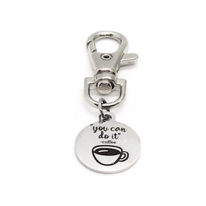 May include: Silver keyring with a round charm that says "you can do it" -coffee and has a picture of a coffee cup.