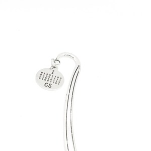 Könnte beinhalten: Silbernes Lesezeichen mit einem runden Anhänger, auf dem "I <3 CS" steht und ein binäres Codemuster zu sehen ist.