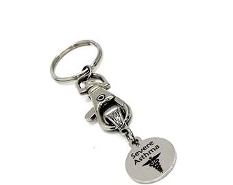May include: Silver keychain with a silver clip and a round tag that says "Severe Asthma" with a medical symbol.
