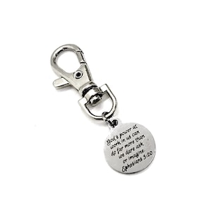 May include: Silver keychain with a round charm that reads "God's power at work in us can do far more than we dare ask or imagine. Ephesians 3:20".