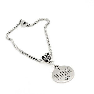 Può includere: Una collana a catena d'argento con un ciondolo rotondo che dice "I <3 CS" in codice binario.