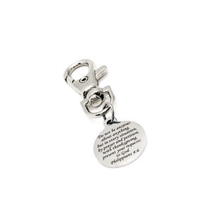 May include: Silver keychain with a round charm that has the text "Do not be anxious about anything, but in every situation, by prayer and petition, with thanksgiving, present your requests to God. Philippians 4:6" engraved on it.