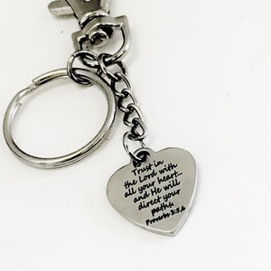 May include: Silver heart-shaped keychain with a silver chain and a silver ring. The heart has the text "Trust in the Lord with all your heart... and He will direct your paths Proverbs 3:5,6" engraved on it.