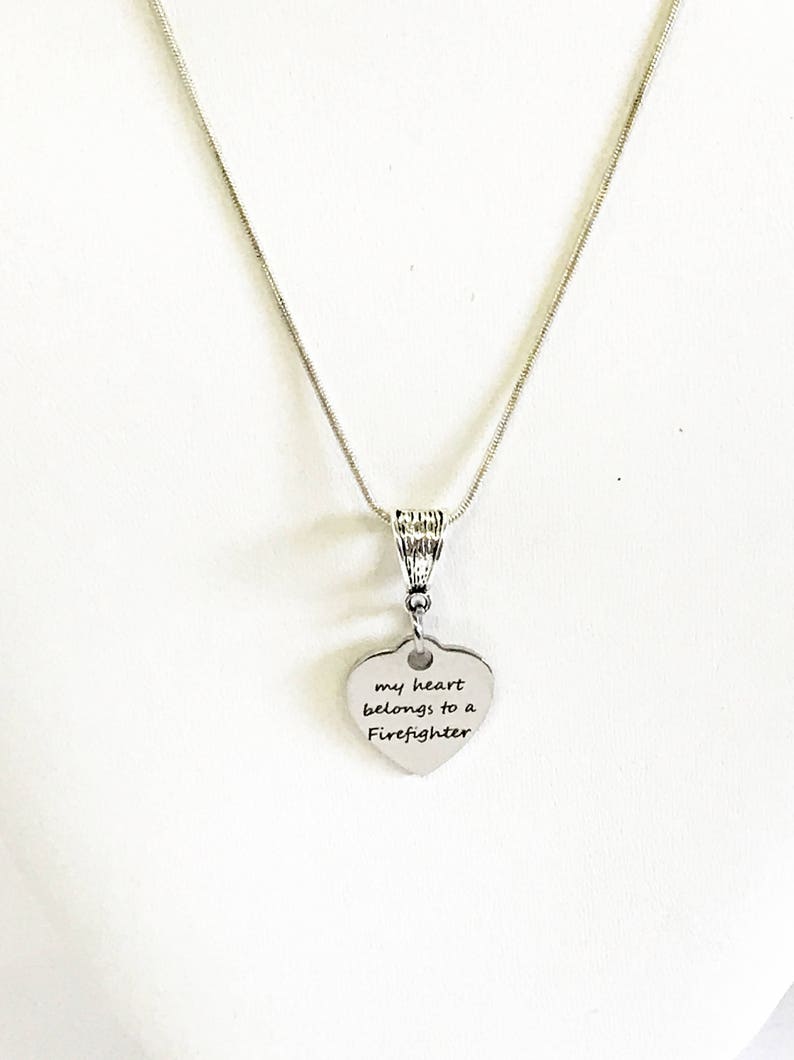 May include: Silver necklace with a heart-shaped pendant that reads "my heart belongs to a Firefighter".