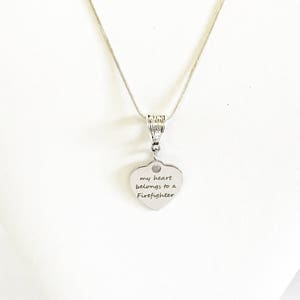 May include: Silver necklace with a heart pendant that says "my heart belongs to a Firefighter".