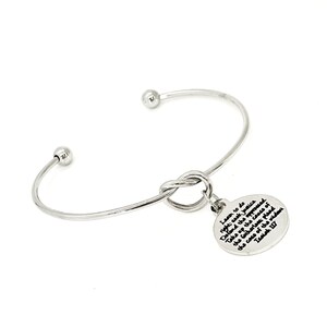 May include: Silver bangle bracelet with a knot charm and a round charm with the text "Learn to do right: seek justice. Defend the oppressed. Take up the cause of the fatherless. Plead the case of the widow." Isaiah 1:17