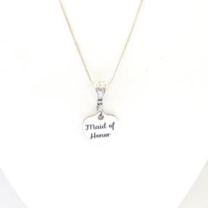 Puede incluir: Collar de plata con un colgante en forma de coraz&oacute;n que dice "Maid of Honor".