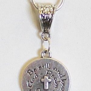 May include: Silver necklace with a round pendant that says "Be still and know that I am God" with a small cross in the center.