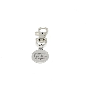 May include: Silver keychain with a round tag that says "Sometimes I go off on tangents".