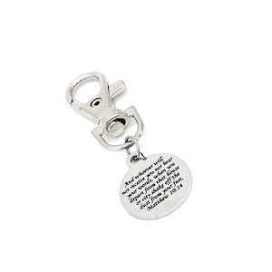 May include: Silver keychain with a round charm featuring a bible verse: "And whoever will not receive you nor hear your words, when you depart from that house or city shake off the dust from your feet. Matthew 10:14"