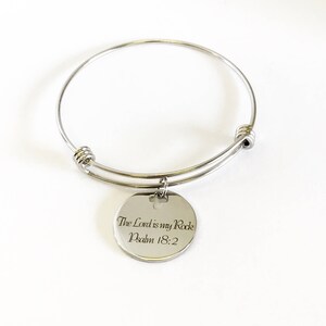 Może przedstawiać: Srebrna bransoletka z okrągłym wisiorkiem z napisem "The Lord is my Rock Psalm 18:2".