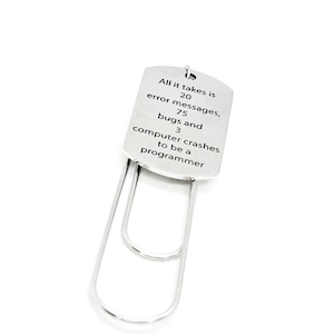 May include: A silver bookmark shaped like a paperclip with the text "All it takes is 20 error messages, 75 bugs and 3 computer crashes to be a programmer" engraved on it.