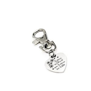 May include: Silver heart-shaped keychain with a silver clasp. The heart has the text "Sisters in Christ are Sisters for Life" engraved on it.