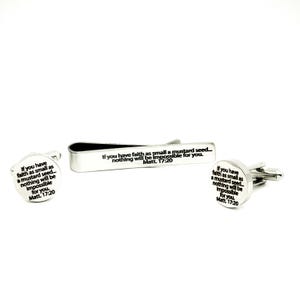 May include: A silver-toned tie clip and two cufflinks set. Each piece features the engraved text "If you have faith as small as a mustard seed... nothing will be impossible for you. Matt. 17:20". The cufflinks are round.