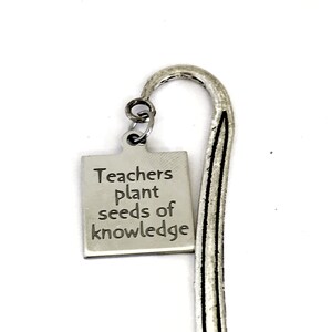 May include: Silver bookmark with a rectangular tag that reads "Teachers plant seeds of knowledge".