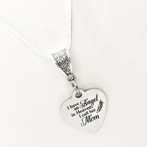 May include: Silver necklace with a heart-shaped pendant that reads "I have an Angel in Heaven, I call her Mom".