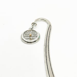 May include: Silver metal bookmark with a curved top and a circular charm. The charm has text that reads "If you have faith as small as a mustard seed... nothing will be possible for".