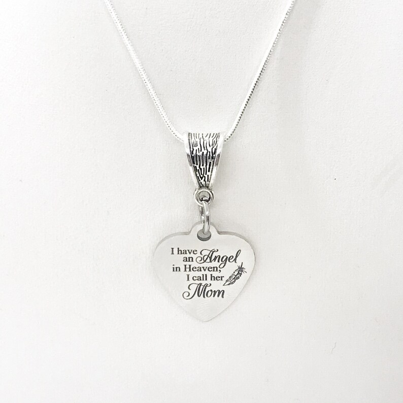May include: Silver necklace with a heart-shaped pendant that reads "I have an Angel in Heaven, I call her Mom".