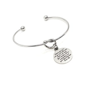 May include: A silver bangle bracelet with a knotted charm. The charm has the text "Where you go I will go and where you stay I will stay. Your people will be my people and your God My God. Ruth 1:16"