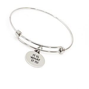 May include: Silver bangle bracelet with a round charm that says "It is what it is!"