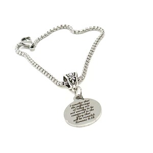 May include: A silver bracelet with a round charm that has the text "I consider that the sufferings of today are not worthy to be compared to the glory that will be revealed. Romans 8:18" engraved on it.