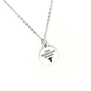 May include: Silver necklace with a round pendant that says "Von Willebrand Disease" and has a medical symbol.