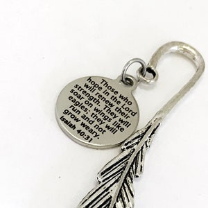 May include: Silver bookmark with a feather design and a round charm with the text "Those who hope in the Lord will renew their strength. They will soar on wings like eagles; they will run and not grow weary. Isaiah 40:31"