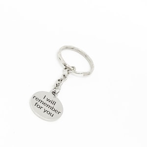 May include: Silver keychain with a round charm that says "I will remember for you".