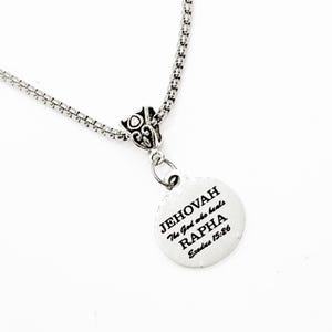 Puede incluir: Collar de plata con un colgante redondo que dice "JEHOVAH El Dios que sana RAPHA Éxodo 15:26".