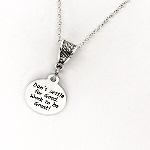 May include: Silver necklace with a round pendant that reads "Don't settle for Good. Work to be Great!"