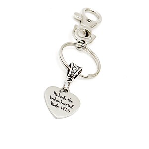 May include: Silver keychain with a heart-shaped charm that reads "He heals the broken hearted. Psalm 147:3"