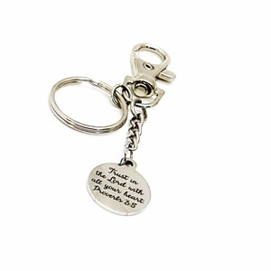 May include: Silver keychain with a round charm that says "Trust in the Lord with all your heart. Proverbs 3:5".
