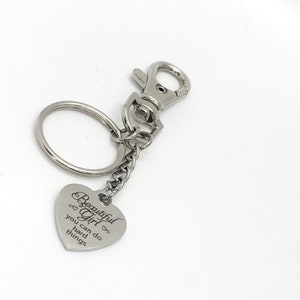 May include: Silver keychain with a heart-shaped charm that reads "Beautiful Girl you can do hard things".