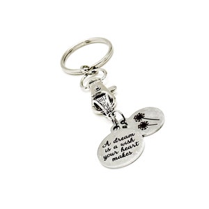 May include: Silver keyring with a round charm that says "A dream is a wish your heart makes" and a smaller charm with two dandelions.