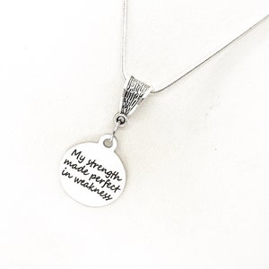 May include: Silver necklace with a round pendant that says "My strength made perfect in weakness".