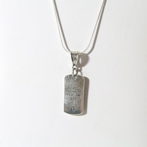 May include: Silver necklace with a silver tag pendant that reads "Be still and know that I am God".