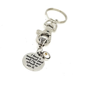 May include: Silver keychain with a small round charm that says "I have a mustard seed and I'm not afraid to use it."