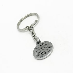 May include: Silver keychain with a round charm that reads "We didn't give you the gift of life. Life gave us the gift of you."