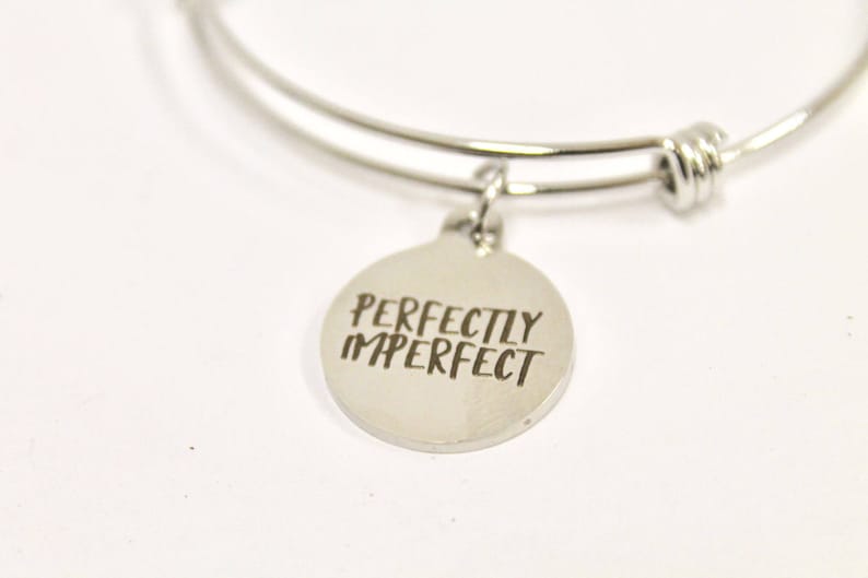 Peut inclure: Bracelet en argent avec un charme qui dit "Parfaitement imparfait".