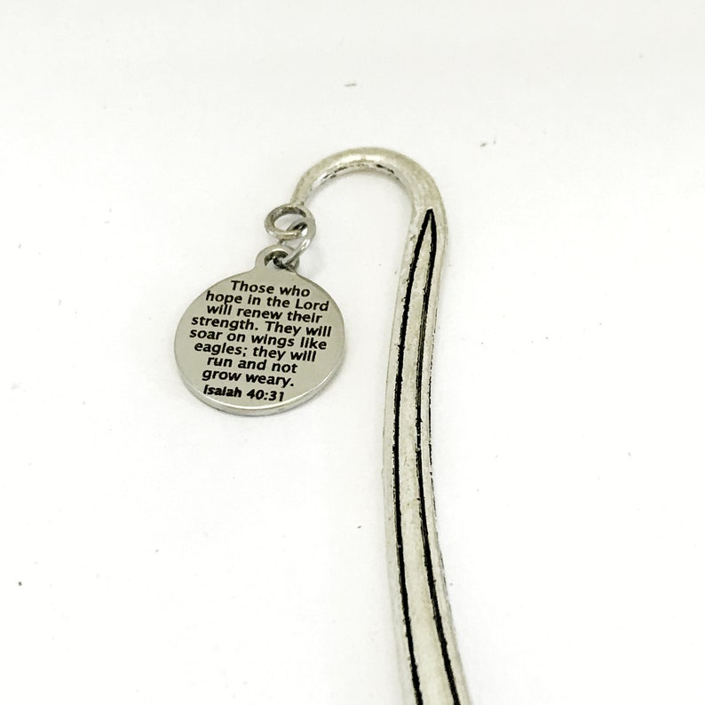 May include: Silver bookmark with a round charm featuring the bible verse "Those who hope in the Lord will renew their strength. They will soar on wings like eagles; they will run and not grow weary. Isaiah 40:31"