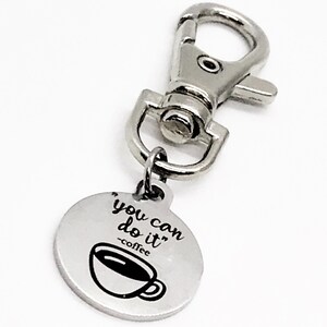 May include: Silver keyring with a round charm that says "You can do it - coffee" with a coffee cup graphic.