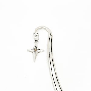 May include: Silver bookmark with a star-shaped charm. The star has a small, round, beige stone in the centre.