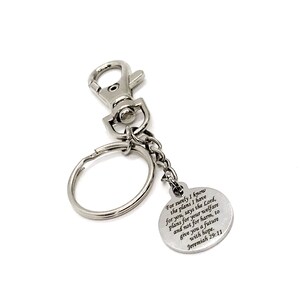 May include: Silver keychain with a round charm that has the text "For surely I know the plans I have for you, says the Lord, plans for your welfare and not for harm, to give you a future with hope. Jeremiah 29:11" engraved on it.
